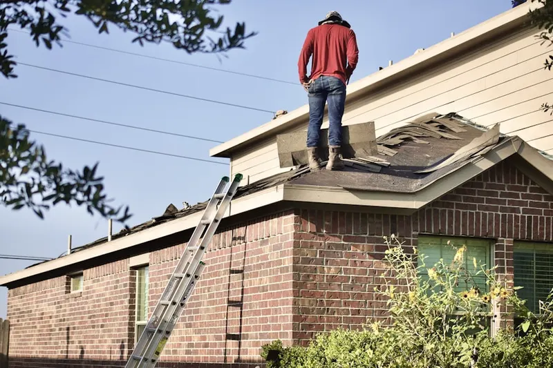 Professional roofer working on a residential roof in Summerfield Village
